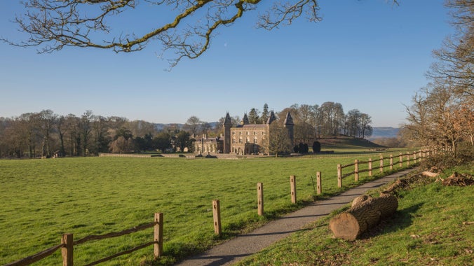 A view across a field, with a fence in the foreground, towards Newton House at Dinefwr, Carmarthenshire
